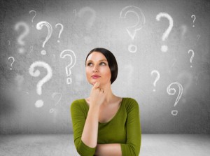 Beautiful woman with questioning expression and question marks a